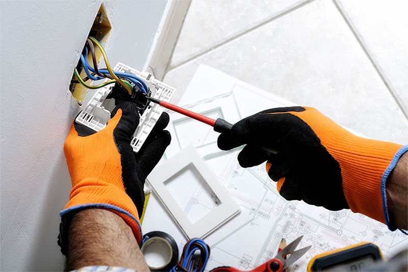 7 Electrical Upgrades for Your Linville Home. Photo of an electrician working on an outlet.